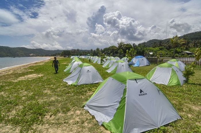 Seorang pengunjung berjalan di dekat tenda yang didirikan di area camping ground Kuta Beach Park The Mandalika, Kecamatan Pujut, Praya, Lombok Tengah, NTB, Rabu (9/3/2022).&nbsp;