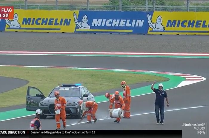 Marshal membersihkan aspal dari tumpahan oli motor Alex Rins 