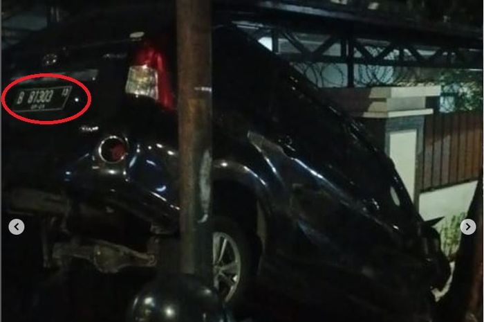 Toyota Veloz hitam bernopol khusus nungging, kejepit antara pohon dan tiang listrik di depan rumah warga di Jalan Raya Kramat Pela, Kebayoran Baru, Jaksel