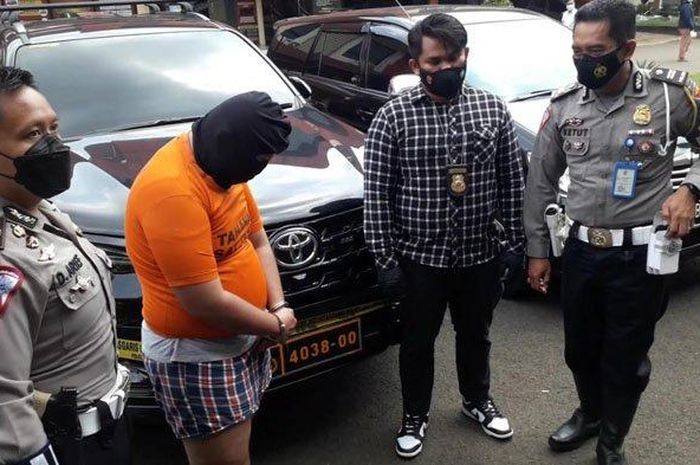 Berbaju tahanan oranye, ZP (28) mahasiswa yang mengaku anggota Densus 88 saat ugal-ugalan bawa Toyota Fortuner bernopol dinas Polri palsu di Puncak Bogor