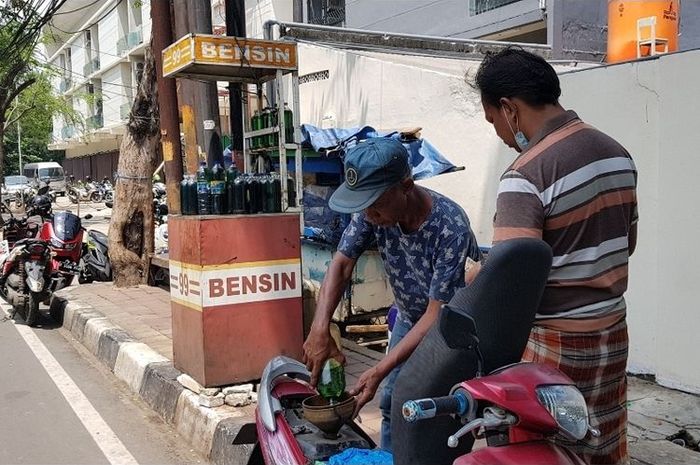 Siswo (55), seorang penjual bensin eceran di Jalan Sindang, Koja, Jakarta Utara, saat melayani pelanggannya yang membeli bahan bakar jenis Pertalite, Senin (4/4/2022)