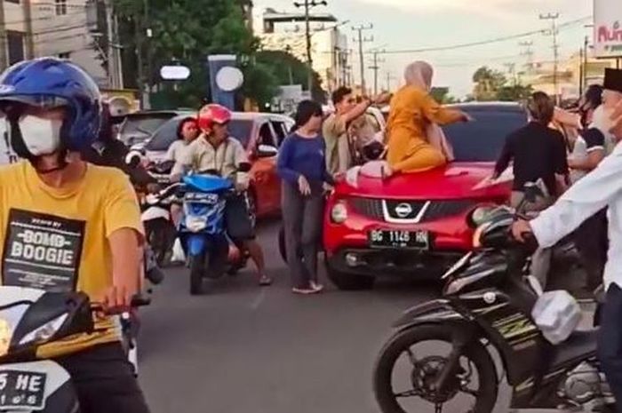 Seorang wanita menggunakan baju kuning nekat naik ke atas kap mobil milik oknum polisi di Polres Lubuk Linggau inisial A lantaran diduga sedang membawa wanita lain di dalam mobil.(TANGKAPAN LAYAR MEDIA SOSIAL)