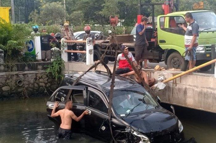 Beberapa warga membantu mengevakuasi mobil yang nyemplung di sungai depan SPBU Jalan Kaligawe Semarang, Kamis (28/4/2022).  