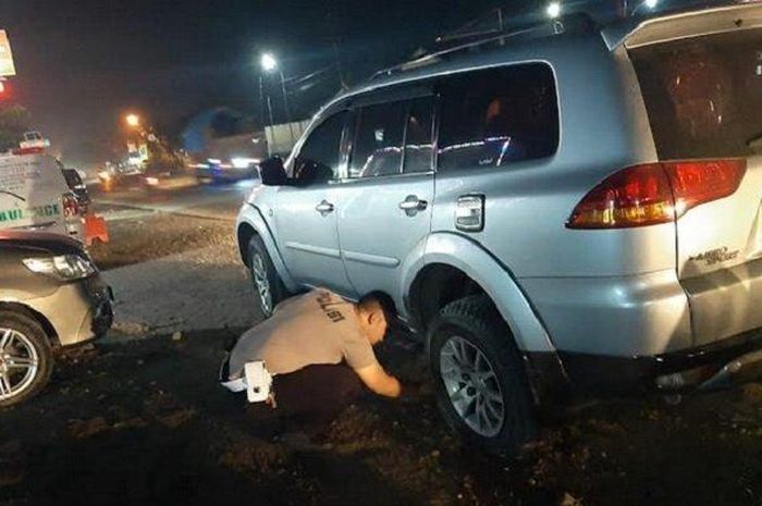 Personel Polres Demak yang rela ngolong buat bantu Mitsubishi Pajero Sport milik pemudik yang pecah ban.