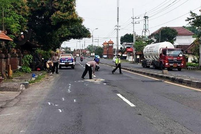 Petugas Unit Laka Satlantas Polres Mojokarto melakukan olah TKP di lokasi kecelakaan yang merenggut korban jiwa di Jalan Raya Trowulan, Kabupaten Mojokerto, Sabtu (30/4/2022). 