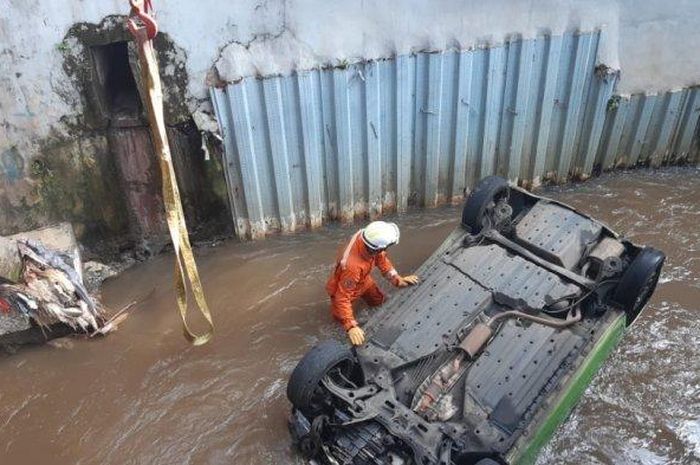 Honda Brio telentang alias terbali usai tercebut di Kali Krukut, Jl Manggis, Ciganjur, Jagakarsa, Jakarta Selatan