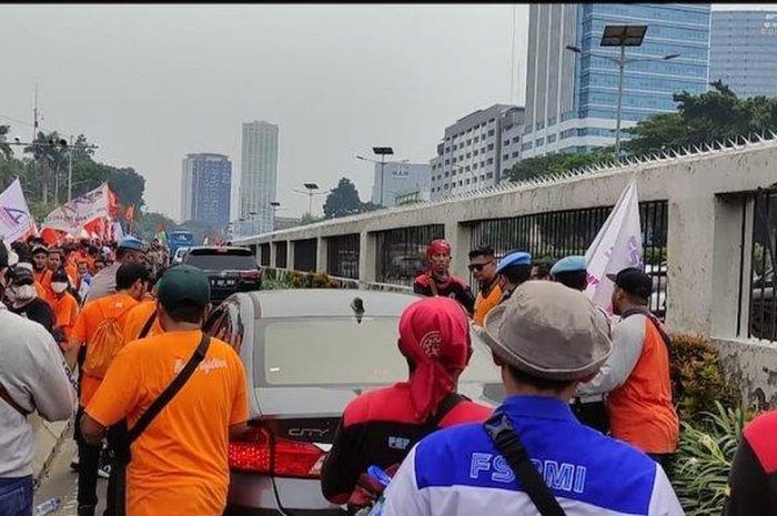 Seorang pengemudi di dalam Honda City berwarna silver hampir jadi korban amukan massa saat aksi buruh di Depan Gedung DPR RI, Senayan, Jakarta Pusat, Sabtu (14/5/2022). 