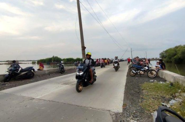 Para pemotor saat melintas di antara tiang listrik yang berada di tengah jalan, Jalan Tanggulsari, Mangunharjo, Tugu, Kota Semarang, Rabu (1/6/2022).