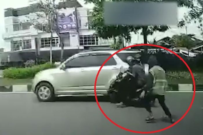 Dalam lingkaran merah, juru parkir tendang dua pemotor hingga tersungkur di Jl Ahmad Arifin, kota Pekanbaru, Riau