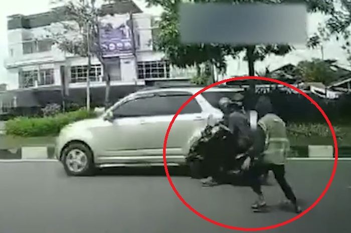 Dalam lingkaran merah, juru parkir tendang dua pemotor hingga tersungkur di Jl Ahmad Arifin, kota Pekanbaru, Riau
