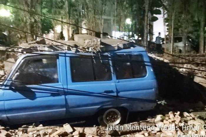 Kondisi Toyota Kijang yang ditimpa reruntuhan tembok akibat hujan deras dan angin menumbangkan pohon yang menyeret tembok di Jl Menteng Atas Selatan, Setiabudi, Jakarta Selatan 
