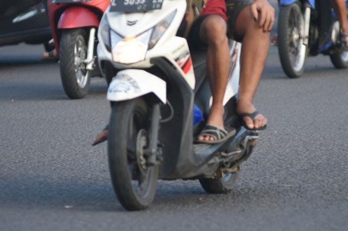 Ilustrasi naik motor pakai sandal. Beredar kabar pengendara motor pakai sandal ditilang di Semarang, Polda Jateng tegaskan itu hoax