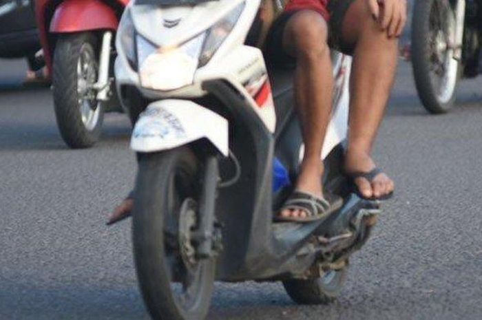 Ilustrasi pengendara motor memakai sandal jepit.