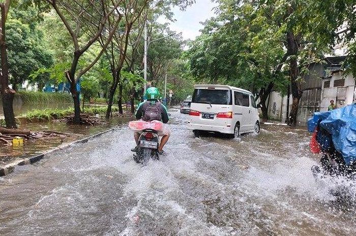 Sejumlah Pemotor Nekat Melintasi Banjir di Jalan Bolong Raya, Jakarta Timur