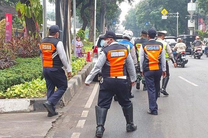 Petugas Sudin Perhubungan dan Satlantas Polres Metro Jakarta Pusat menindak mobil yang kedapatan parkir sembarangan
