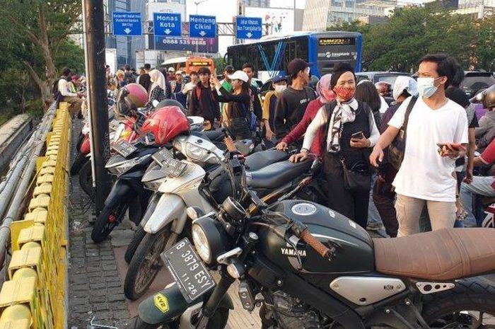 Parkir motor pengunjung Citayam Fashion Week di trotoar di kawasan Dukuh Atas, Jakarta Pusat