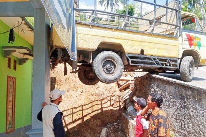 Pikap nyangkut di atap rumah warga