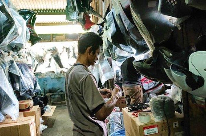 Satu di antara penjual body part kendaraan di Kokrosono Kota Semarang tengah mengemas barang dagangannya, Selasa (16/8/2022). 