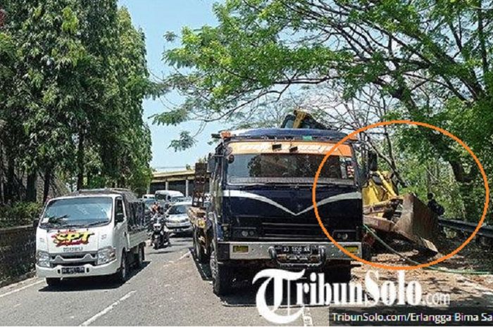 Penampakan kondisi truk dan buldoser yang mendadak jatuh saat diangkut sehingga menyebabkan Jalan Raya Wonogiri-Solo tersendat, Jumat (2/9/2022) siang.