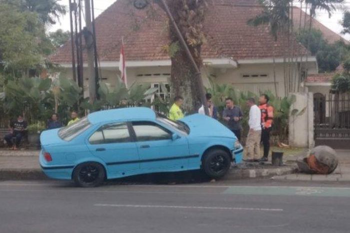 BMW 318i E36 naik trotoar lalu tabrak tiang listrik hingga melengkung di Jalan Besar Ijen, kota Malang, Jawa Timur