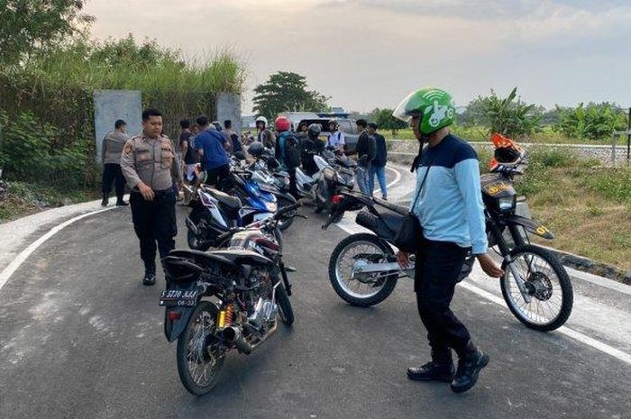 Petugas yang megnamankan motor dan para pelaku balap liar di Mojokerto, Selasa (06/09/2022).