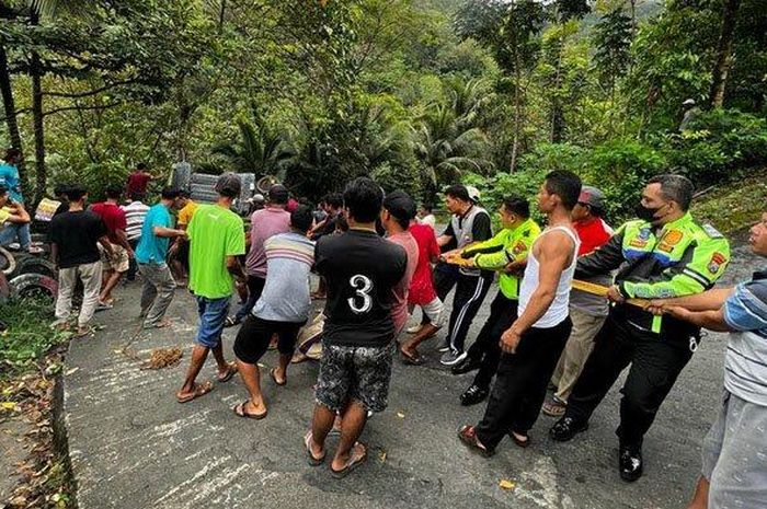 Warga dan polisi gotong royong berusaha menarik truk yang terjun ke jurang sedalam puluhan meter di Trenggalek, Jawa Timur.