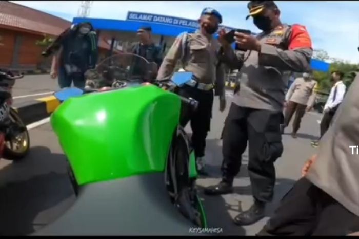 Pihak kepolisian memeriksa STNK di yang diduga ada di ponsel