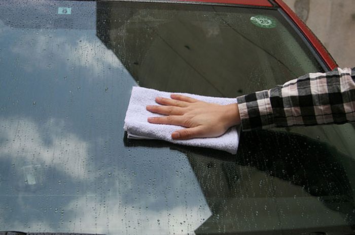 Lap kaca mobil pakai microfiber setelah disemprot dengan glass cleaner agar jamur kaca hilang.
