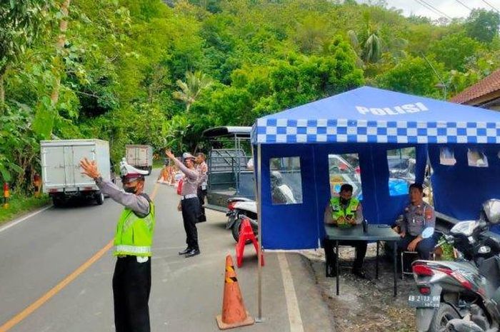 Unit Lantas Polsek Piyungan mendirikan tenda pantauan arus lalu lintas di tempat area tanah longsor di jalan Yogyakarta-Wonosari, Rabu (02/11/2022) 