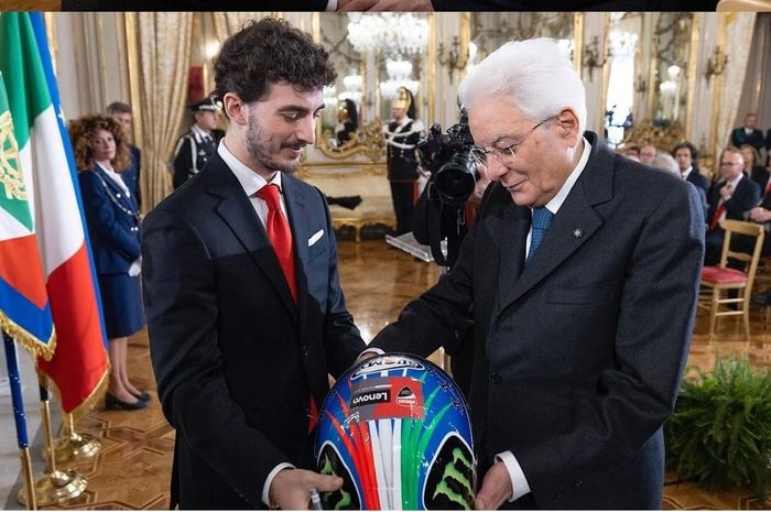 Francesco Bagnaia (kiri) berikan helm ke Presiden Italia Sergio Mattarella