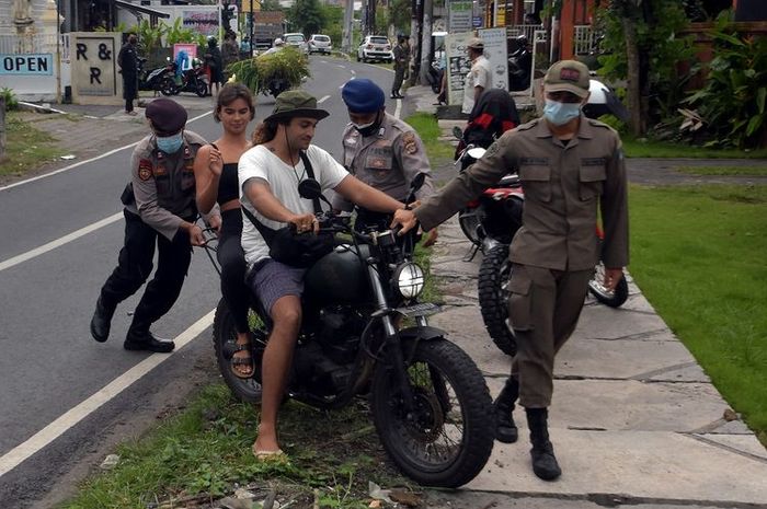 ilustrasi - WNA tidak memakai helm yang diberhentikan oleh Satpol PP dan Polisi.