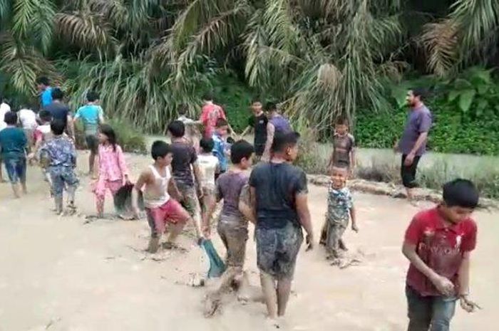 Puluhan anak-anak mengikuti lomba tangkap ikan di tengah jalan Desa Padang Pulau, Kecamatan Bandar Pulau, Kabupaten Asahan, Jumat (2/12/2022)
