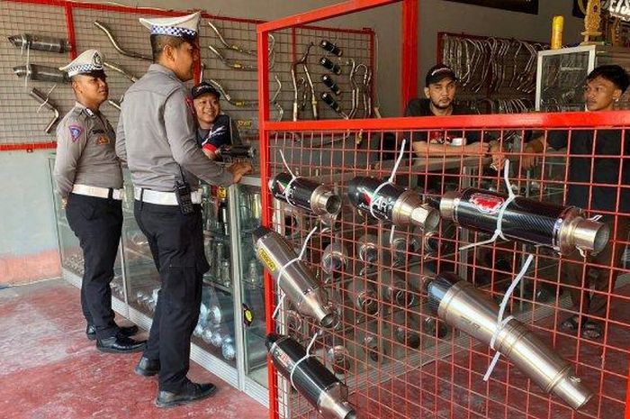 Personel Satuan Lalu Lintas Polresta Mataram mengedukasi penjual knalpot brong, di salah satu toko knalpot brong, Sriwijaya, Kota Mataram, Rabu (14/12/2022). 