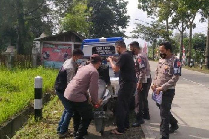 Petugas polisi saat mengevakuasi motor yang terlibat kecelakaan lalu lintas dengan truk i ruas jalan Desa Kembangan Kecamatan Bukateja Kabupaten Purbalingga Jumat (16/12/2022) pagi. 