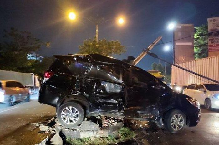 Toyota Kijang Innova Reborn tersangkut di pembatas jalan usai diseret dump truck sejauh 10 meter saat hendak masuk gerbang tol Krapyak, Semarang