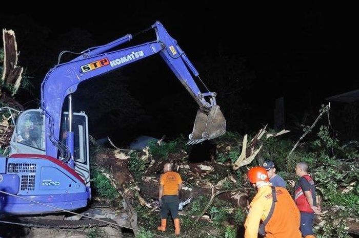 Petugas BPBD, bersama polisi dan relawan mengevakuasi pohon roboh di sekitar kawasan Pemandian Muncul, Desa Rowobani, Kecamatan Banyubiru, Kabupaten Semarang Kamis (22/12/2022) tengah malam. 