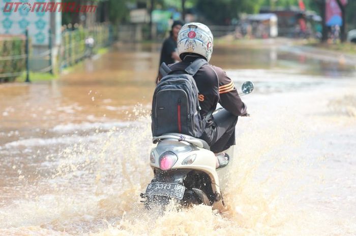 Ilustrasi menerobos banjir dengan motor matic