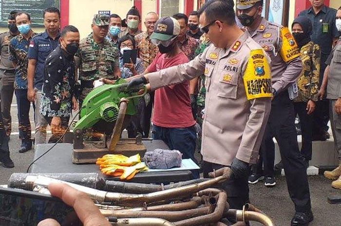 Kapolres Blitar, AKBP Aditya Panji Anom memotong knalpot brong menggunkan alat gerinda hasil razia.