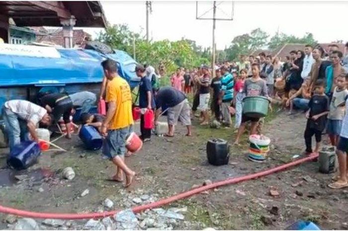 Warga berebut Solar yang tumpah setelah truk tangki pengangkutnya terguling di desa Teluk Lubuk, Belimbing, Muara Enim, Sumatera Selatan