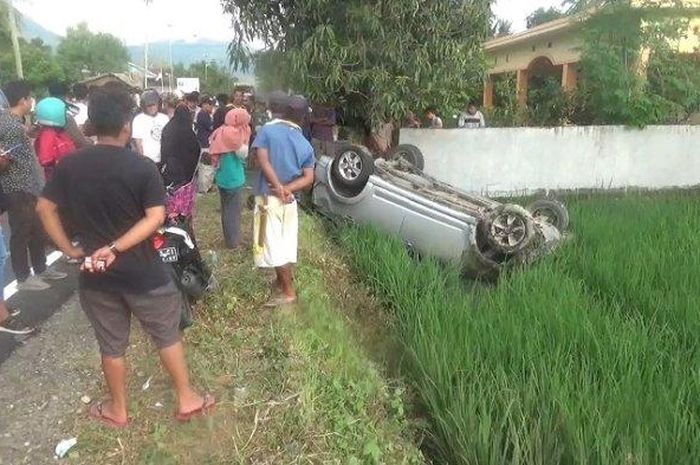 Toyota Rush kayang tatap langit di sawah setelah terhempas menabrak pemotor hingga tewas di desa Rea Timur, Binuang, Polewali Mandar, Sulawesi Barat