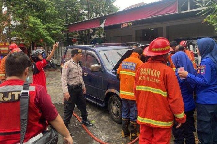 Petugas Damkar Kota Malang saat menaklukkan si jago merah yang melalap mesin Toyota Kijang.