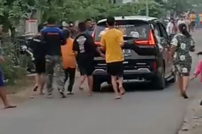 Mitsubishi Xpander hitam dikejar-kejar warga karena pria di dalamnya sebar- duit di jalanan