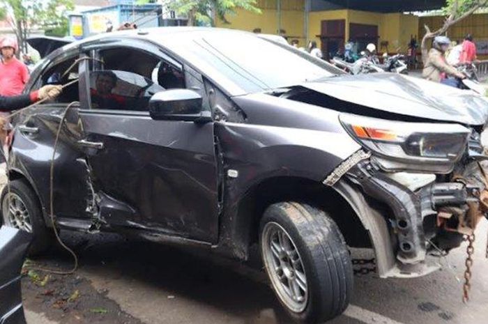 Honda Brio sedang diderek setelah menabrak Yamaha FreeGo, warung kopi, dan pohon di Ponorogo, Minggu (05/02/2023). 