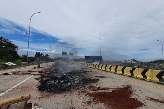 Ruas Jalan Tol Jatikarya diblokade warga menggunakan ban terbakar, pohon pisang dan puing-puing kayu, Rabu (08/02/2023).