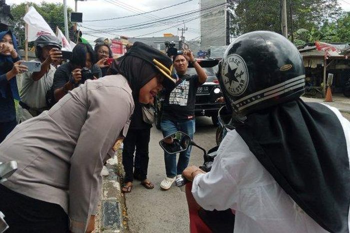 Pengendara motor wanita mendapat minyak goreng gratis saat razia Polisi Operasi Keselamatan Lodaya 2023 di Subang