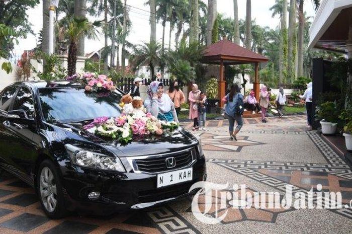 Sejumlah warga berfoto di samping Honda Accord Wali Kota Malang di halaman rumah dinas Wali Kota pada Minggu (12/02/2023). 