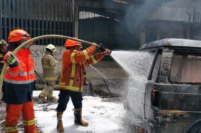 Petuas pemadam kebakaran memadamkan api yang membakar Suzuki Carry akibat korsleting listrik sambar 20 jeriken isi bensin