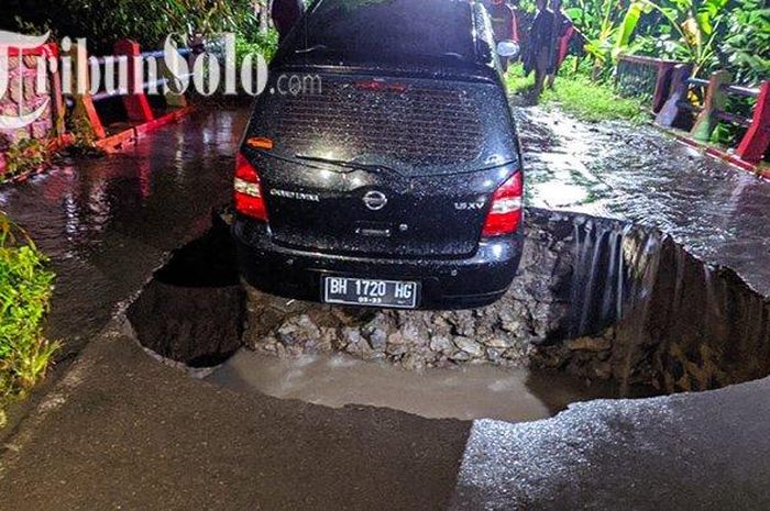 Nissan Grand Livina terjebak dalam jalan yang ambles di atas Jembatan Ledok, Kabupaten Boyolali, Kamis (16/02/2023). 