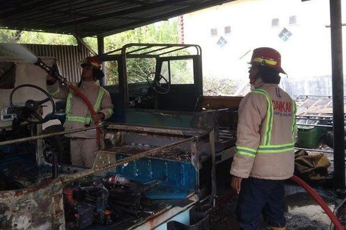 Petugas damkar sedang memadamkan kebakaran di bengkel mobil Desa Tulusbesar, Kecamatan Tumpang, Kabupaten Malang, Jumat (17/02/2023). 