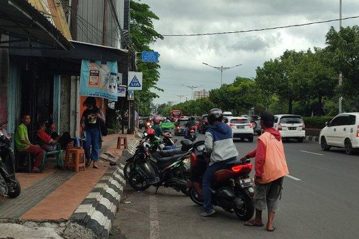 Juru parkir (Jukir) sedang melayani pengguna parkir yang hendak pergi di Jalan Mgr Suyigopranoto, Bulustalan, Semarang Selatan, Kota Semarang (18/2/2023). 